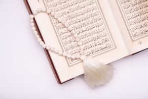 مصحف مفتوح على طاولة مع ضوء هادئ، رمزًا لتدبر القرآن واختيار السور المحببة إلى الله.